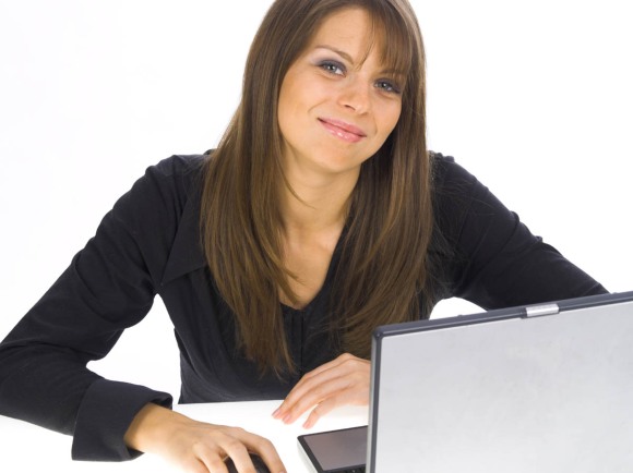 Smiling girl sitting at computer.